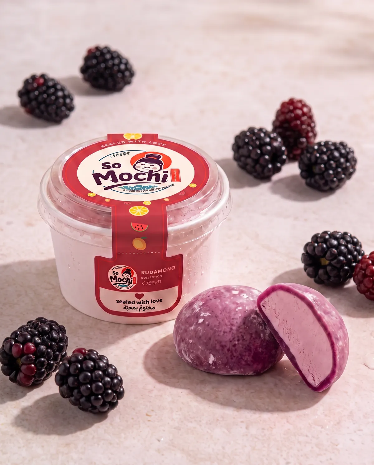 Jumbo Blackberry mochi, whole and cut open, beside its sealed So Mochi cup