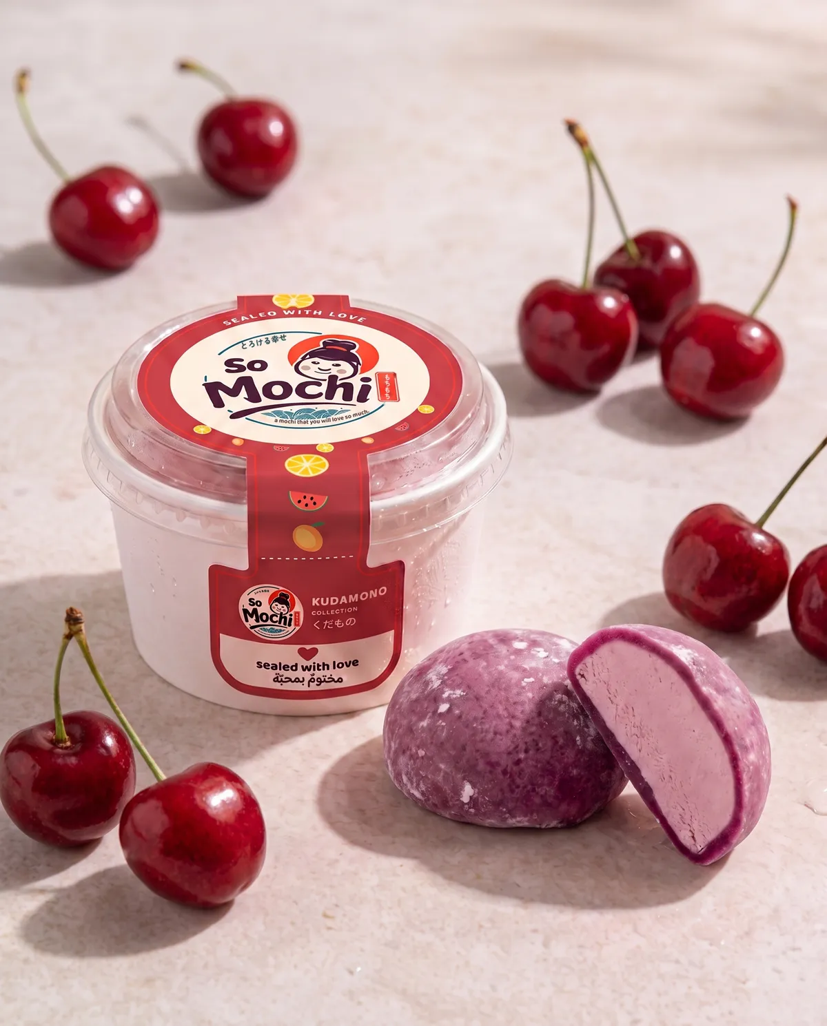 Jumbo Cherry Mania mochi, whole and cut open, beside its sealed So Mochi cup