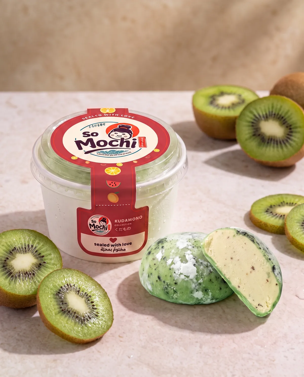 Jumbo Kiwi mochi, whole and cut open, beside its sealed So Mochi cup