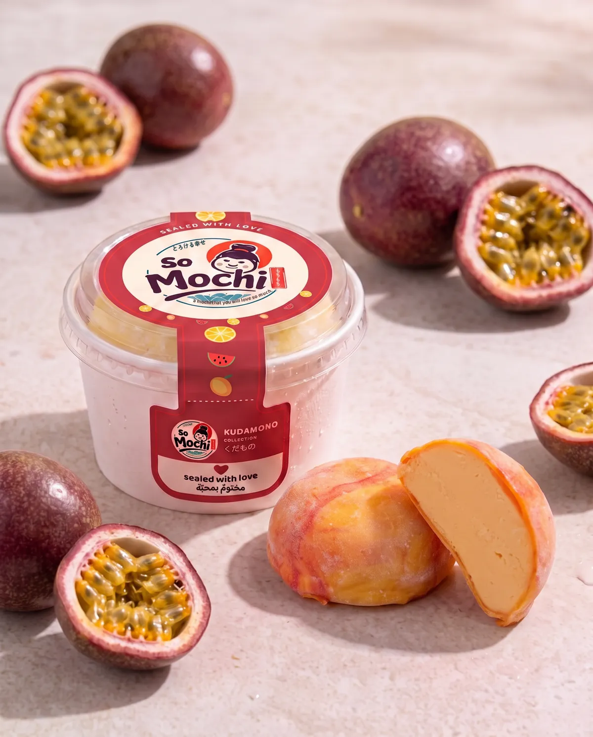 Jumbo Passion Fruit mochi, whole and cut open, beside its sealed So Mochi cup