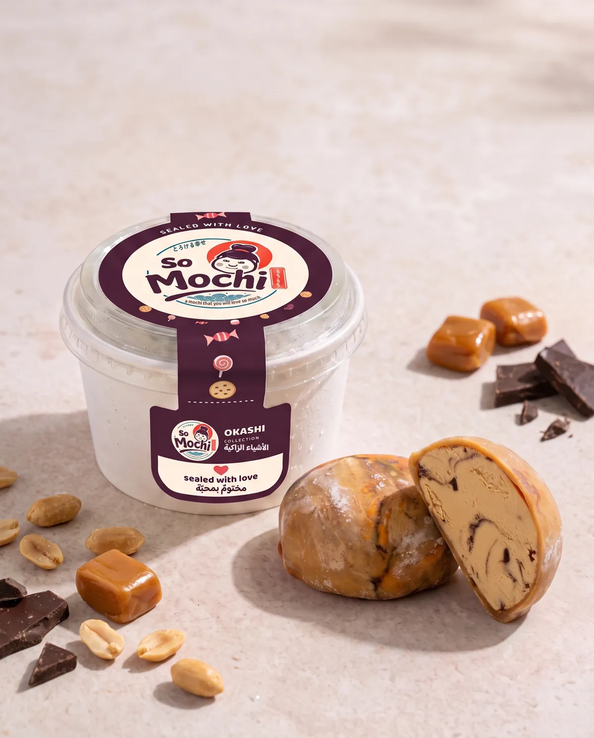 Jumbo Snickers mochi, whole and cut open, beside its sealed So Mochi cup